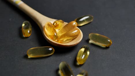 fish oil capsules on wooden spoon