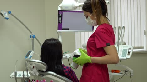 joven dentista tomando una radiografía de la mandíbula usando un dispositivo portátil. filmado en 4k