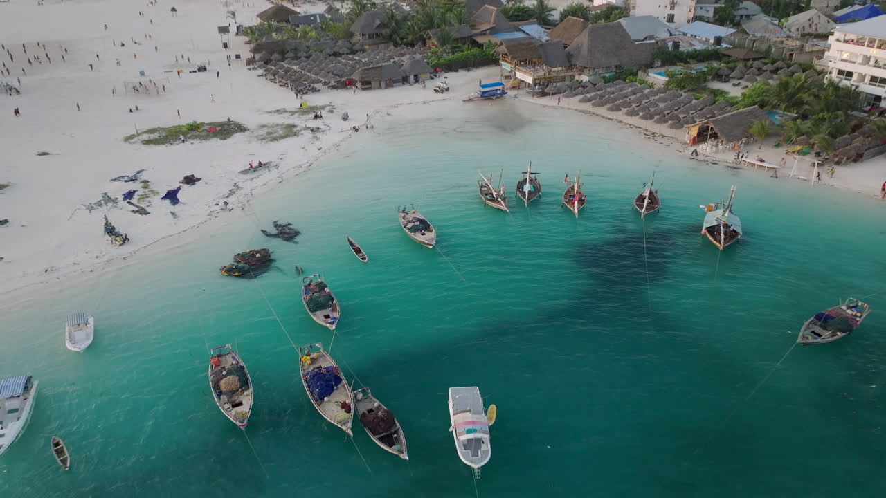 Zanzibar, Tanzanya'daki Kendwa köyünde ahşap balıkçı tekneleri ve kumlu plajın drone görüntüsü.