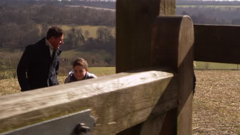 family with dog walking through gate in open countryside, shot on r3d