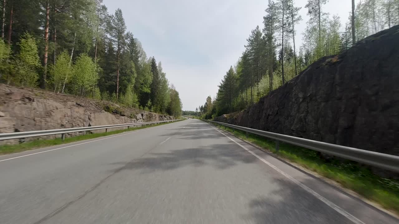 길은 양쪽 모두 울창한 초록색 나무로 여 있으며, 자동차는 이 경치 좋은 경로를 우아하게 가로질러 자연과 조화롭게 여 있습니다.