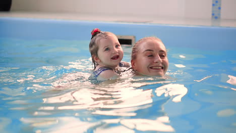 cute baby boy enjoying with his mother in the pool.