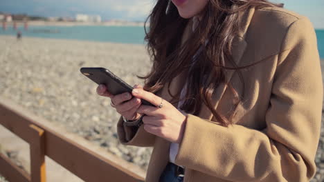 woman using a phone on the beach