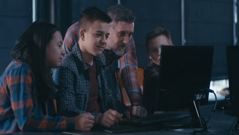 Teenagers learning digital art in a classroom setting with a teacher.
