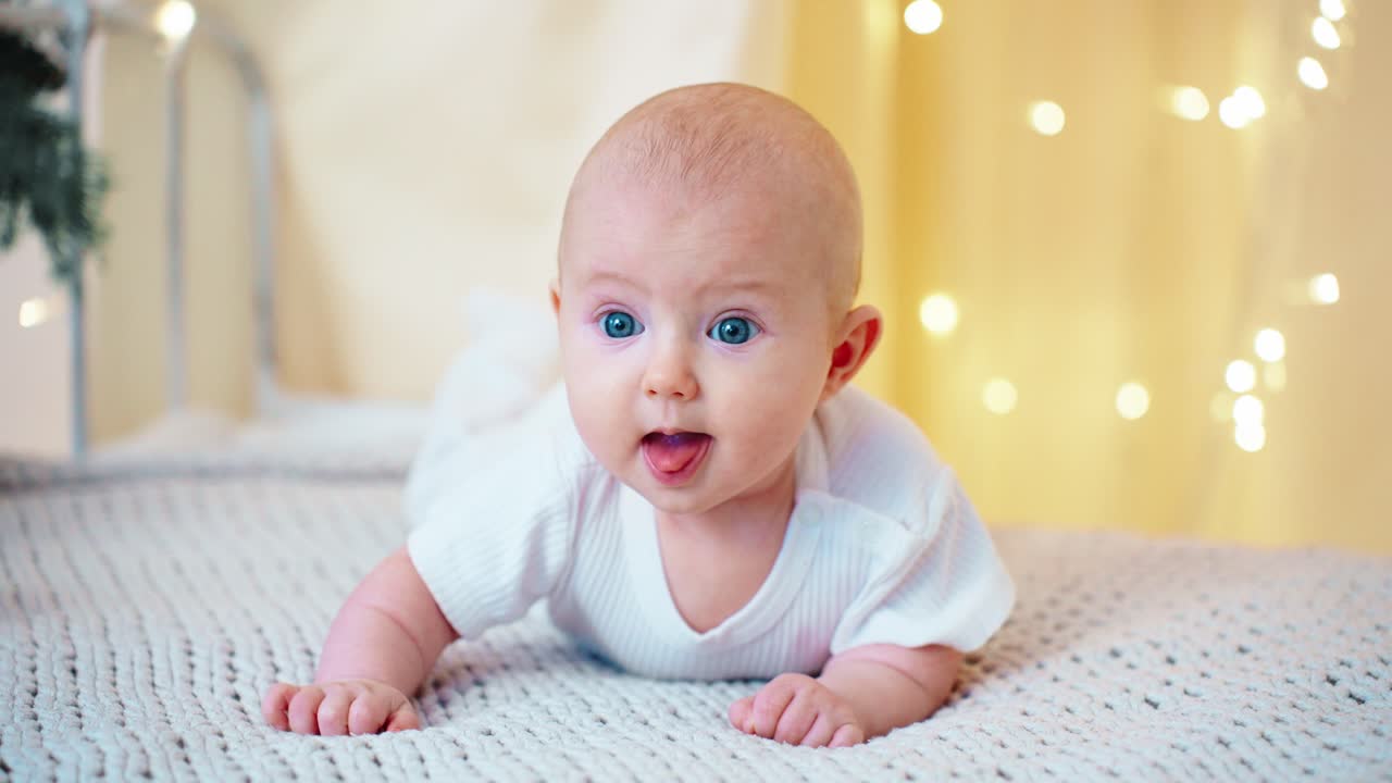 Bebê fofo de bruços em 'tummy time' com luzes bokeh.