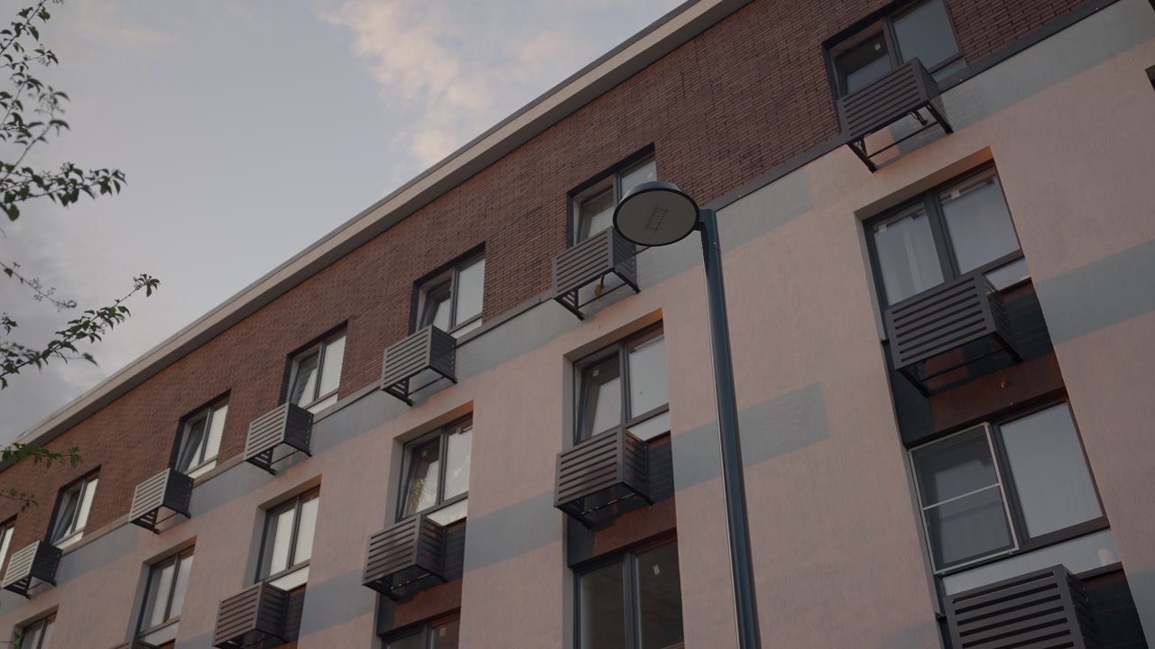 Twilight Lamppost Beside Apartment Block, Muted Sky And Soft Dusk Tones Framing Circular Lamp Head And Brick