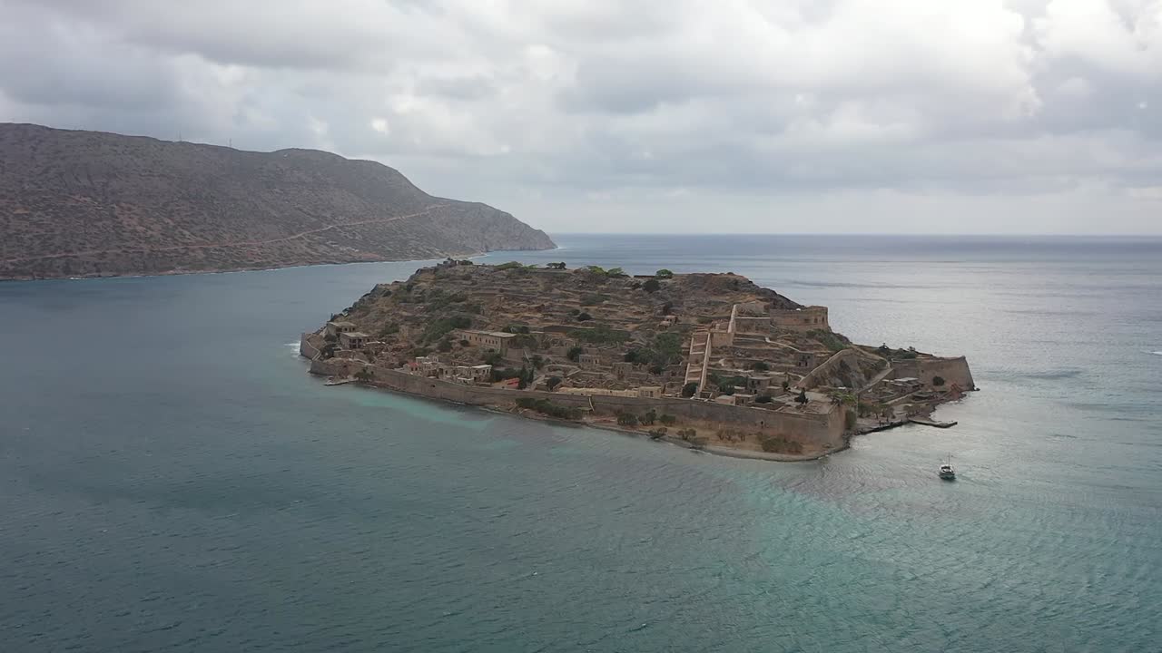 Discover the grandeur of ancient forts on an island, as the drone flies towards the fortress with the picturesque mountain range as the backdrop