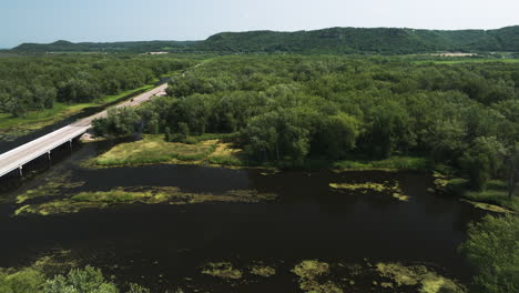 Aerial-shot-of-bridge-road-with-cars-driving-over-wetlands-of-Mississippi-River