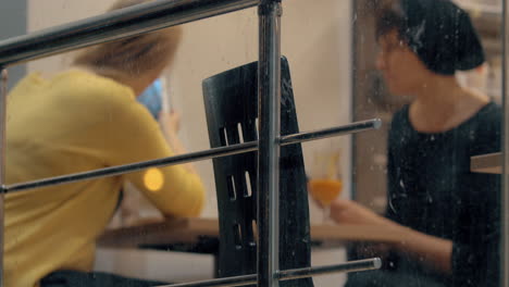 Friends-meeting-in-cafe-Women-using-cell-and-pad