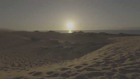 sunset over sand dunes and ocean