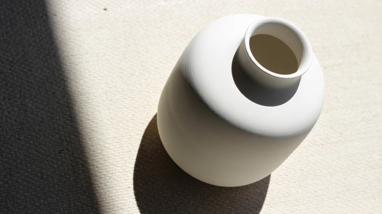 Rotating white vase on cloth by window with sun shifting, cast shadow and dark band changing