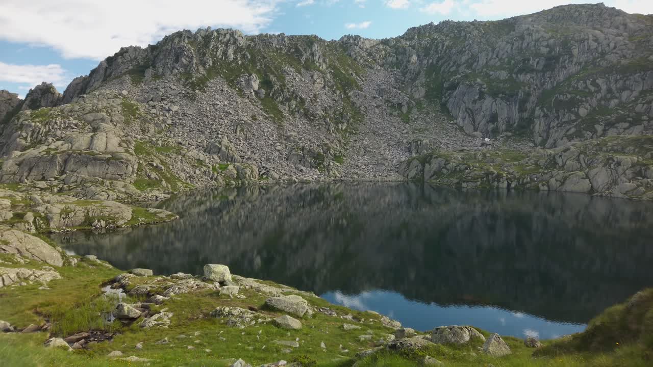 reflejo escénico de montañas y nubes en un pequeño lago en italia