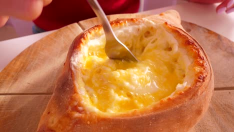 close view egg and cheese khachapuri filling mixed with fork