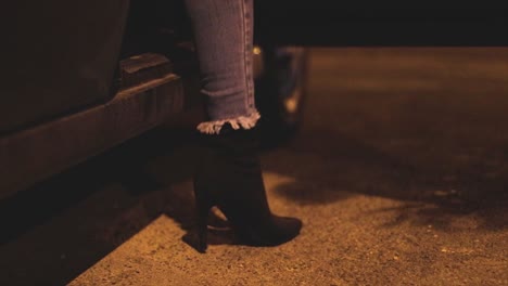girl wearing high heels stepping out of a parked car in slow motion. urban night life concept.