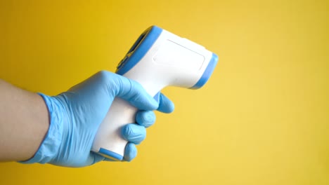 person holding a non-contact thermometer