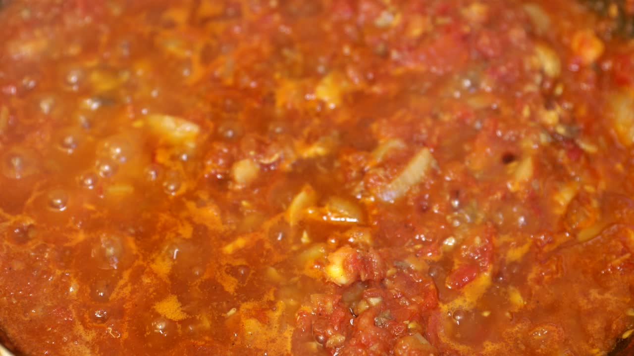 Extreme close up of boiling tomato sauce