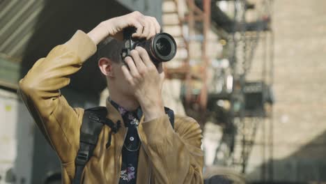 young photographer with digital camera outdoors during sunny day