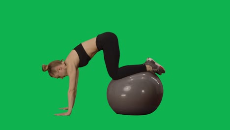 young woman in sportswear performs twisting on fitness ball. workout for arms, back muscles and abdomen, fitness for women. side view full length on green screen background. slow motion ready 59.94fps