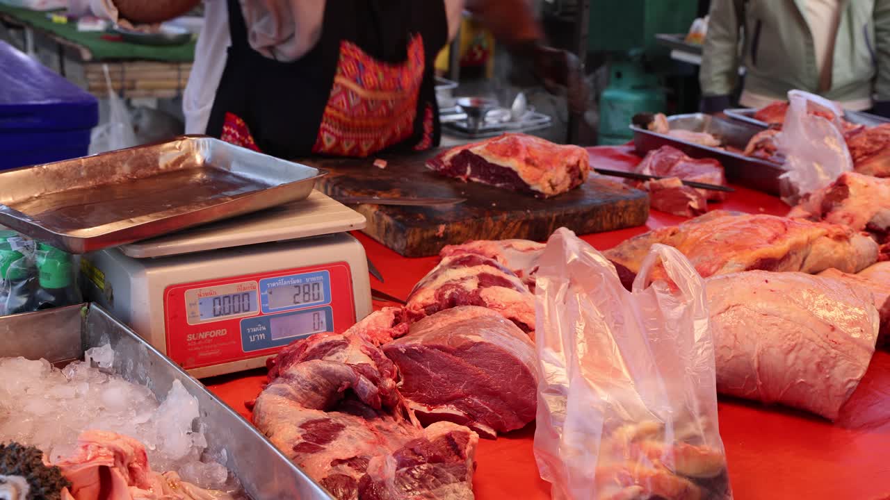 руки мясника взвешивают мясо на цифровых весах.