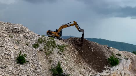 excavadora cavando el suelo en la cima de la montaña y limpiando las rocas