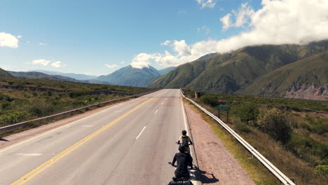 drone passing over cyclists on route 9 in jujuy, argentina, revealing a breathtaking landscape