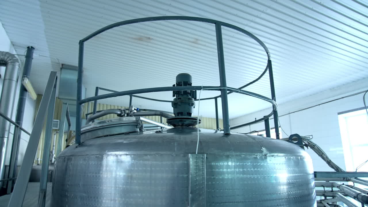 Top of the huge cistern for pasteurizing milk. Huge cisterns standing in a row at the modern production factory. Close up.