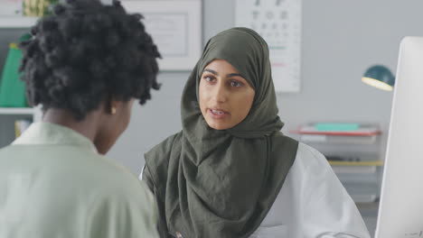 female doctor or consultant wearing headscarf having meeting with female patient