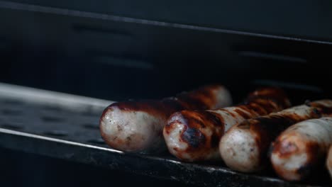 sausages being placed on grill grate after smokey bbq cooking