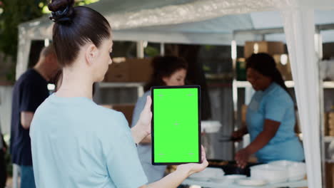 device with green screen held by woman