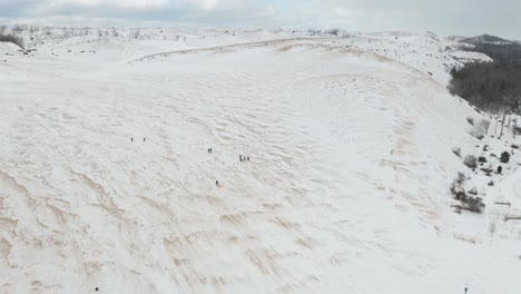 Vista-Aérea-Cinematográfica-De-Personas-En-Trineo-En-Sleeping-Bear-Dunes-National-Lakeshore