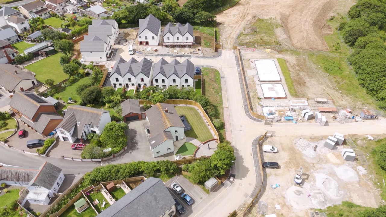 Aerial of new build residential houses being built in Bude, Cornwall, showing the development of modern homes within a scenic and established neighborhood
