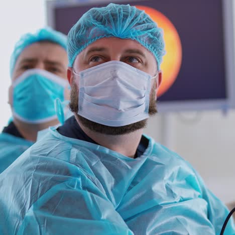 portrait of surgeons. male doctors in medical masks work in the operating room on the monitor background in clinic.