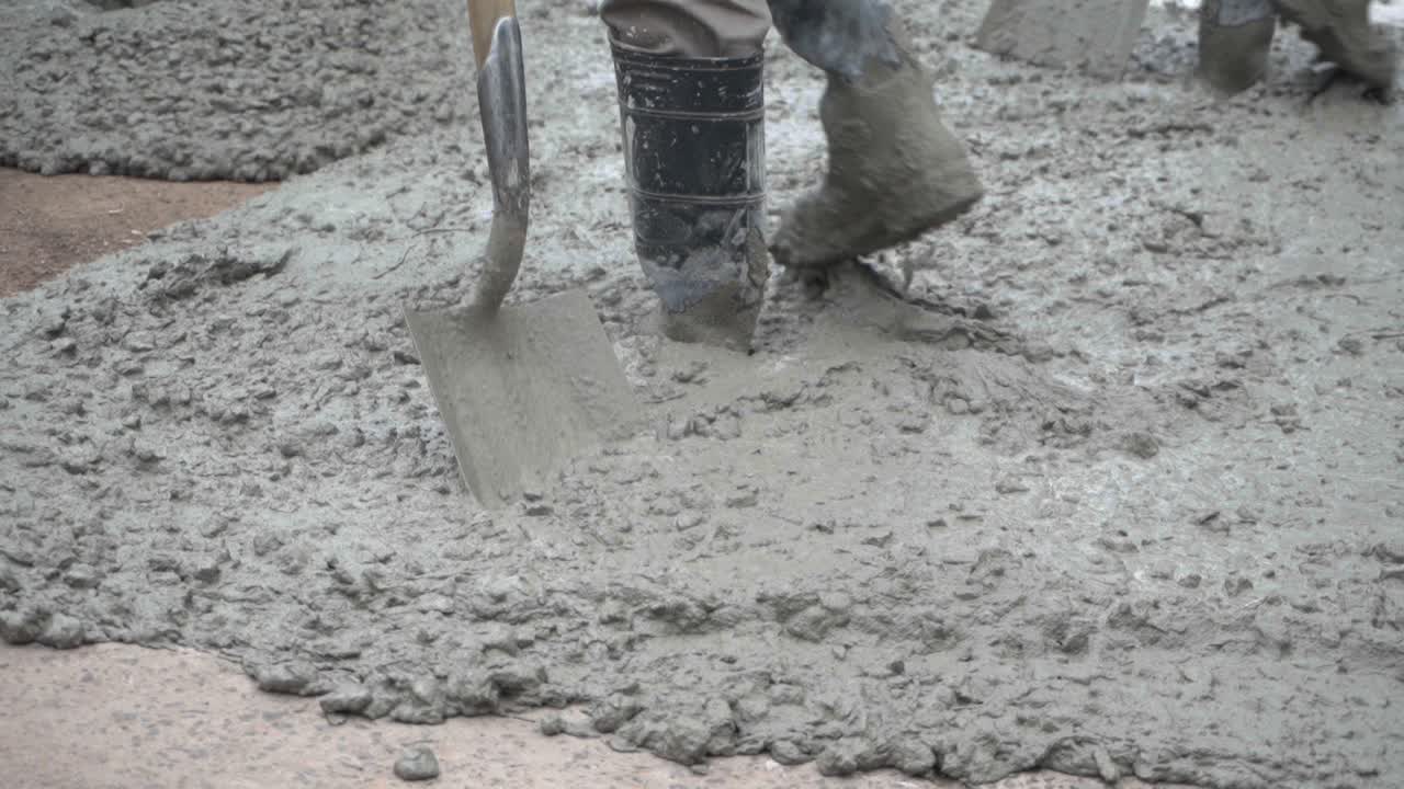 Closeup of a worker working with his shovel on wet concrete