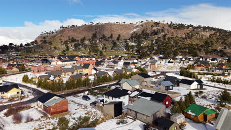 aerial flying over small rural town in caviahue, argentina, covered in winter snow
