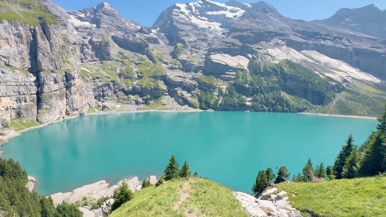 Lago di Oeschinen circondato dalle maestose Alpi svizzere e da un paesaggio montano turchese.