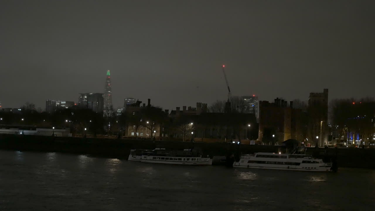 London skyline at night along the bank of the River Thames with The Shard in the background