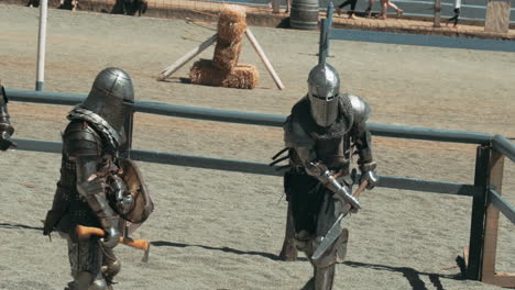 group of armored knights fighting with sword, hatchet and protective shield