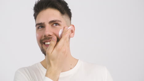 young man applying lotion to his face