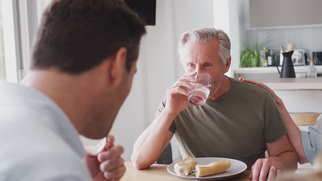 노인 부모 와 성인 자손 이 함께 집 에서 식탁 에 앉아 식사 하는 가족