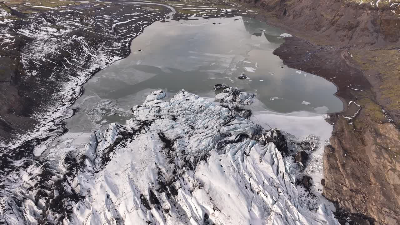 Epic aerial view of Solheimajokull glacier Iceland, melting ice, frozen lagoon and rugged volcanic terrain.