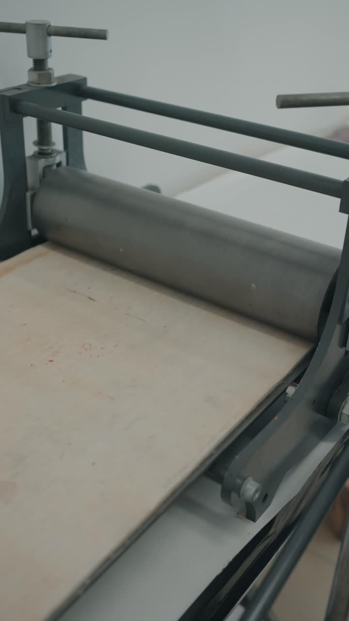 engraving press transfers hand drawn grooves from metal plate vertical