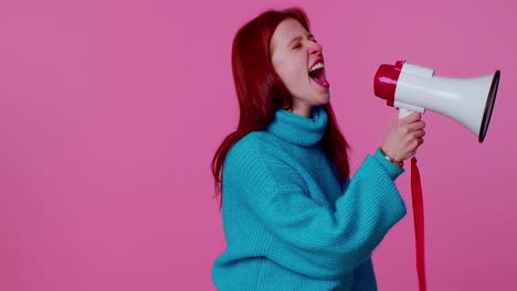 smiling redhead girl talking with megaphone, proclaiming news, loudly announcing sale advertisement