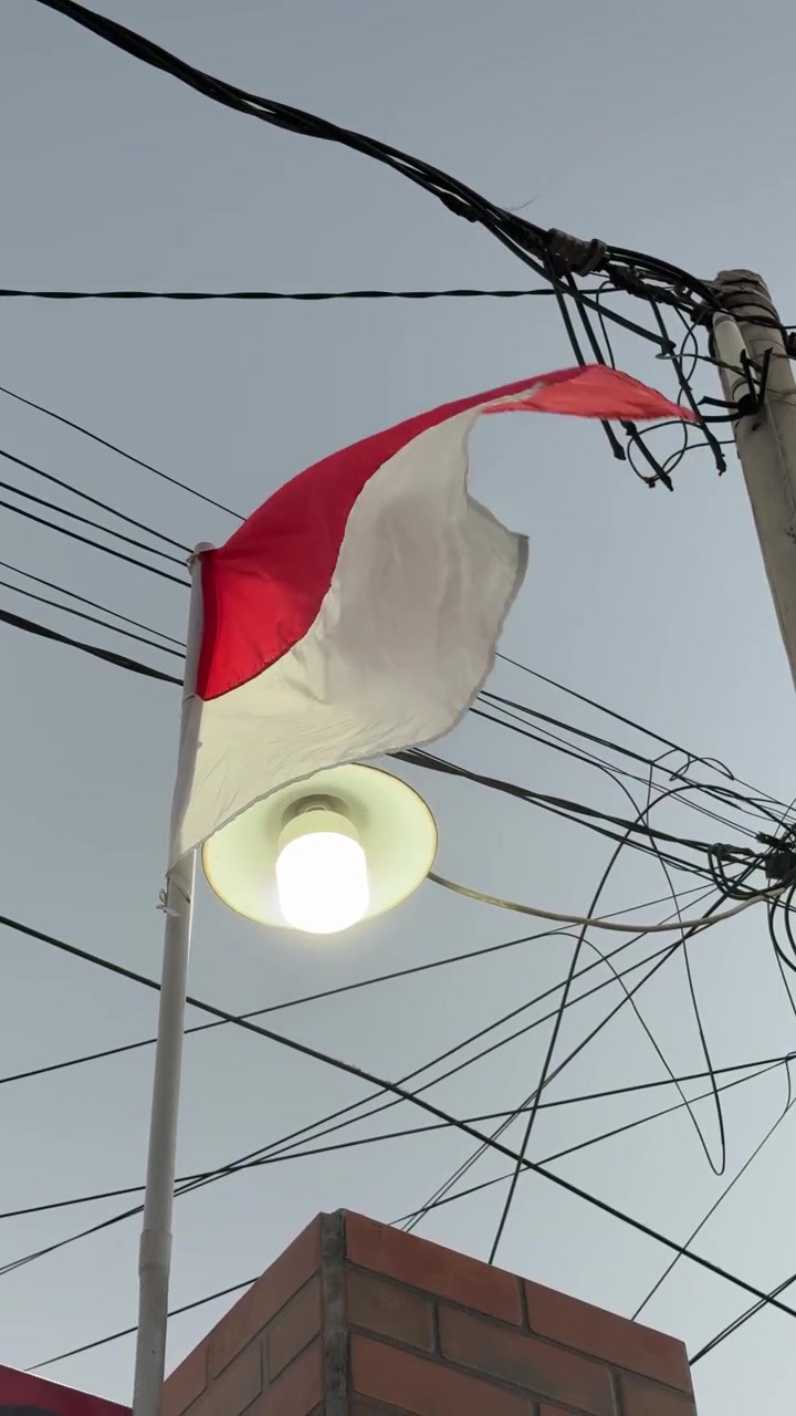 Bandiera indonesiana che sventola al vento contro un cielo nuvoloso