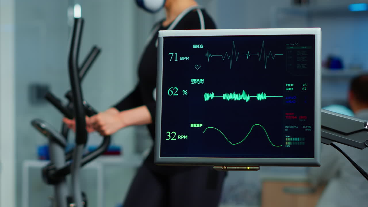 크로스 트레이너를 달리는 운동선수의 ecg 스캔을 보여주는 모니터