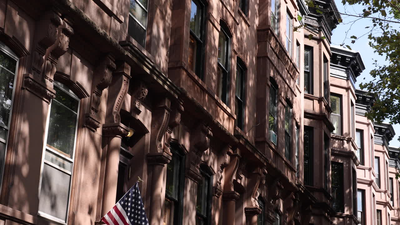 브루클린의 브라운스톤 레드브릭 타운하우스의 파노라마, 미국 발과 함께, 도시 생활의 매력과 애국 정신을 포착합니다.