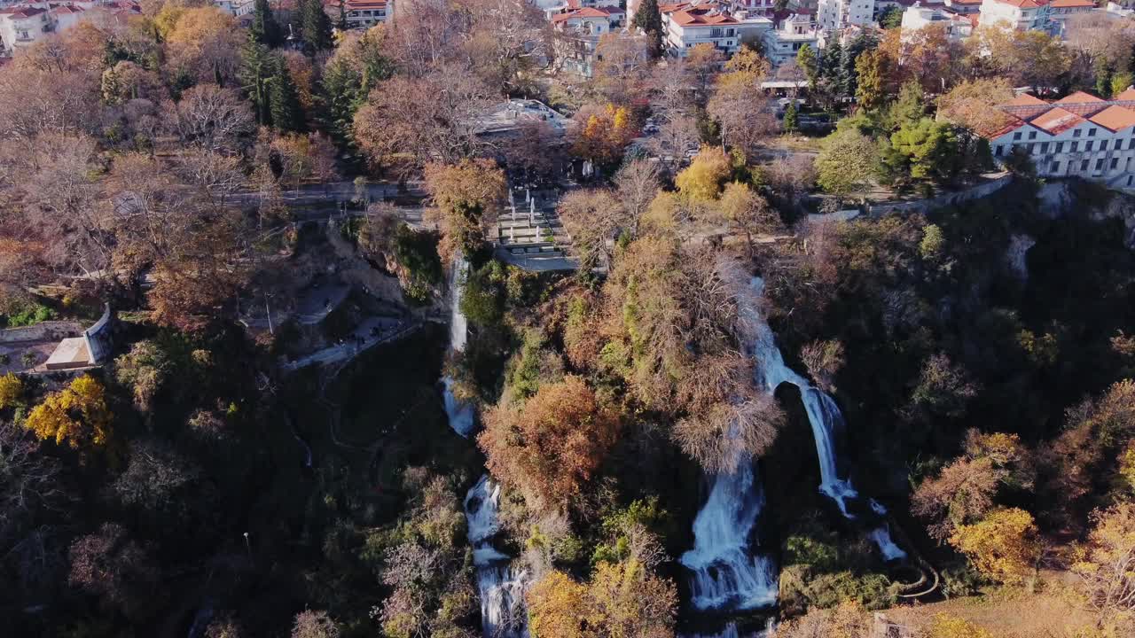 fotografía de drones de la hermosa cascada de edessa en el paisaje forestal durante un día soleado y la ciudad en el fondo, grecia