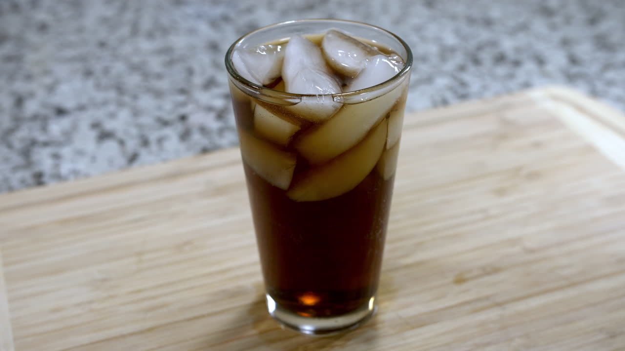 burbujas de soda pop que se elevan en el vidrio colocado en el mostrador