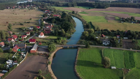 aerial rural shot of a small village and farms by the river