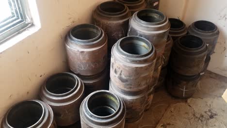 a storage area is depicted filleds with several large cylindrical objects that seem to be railway train wheelset bearings