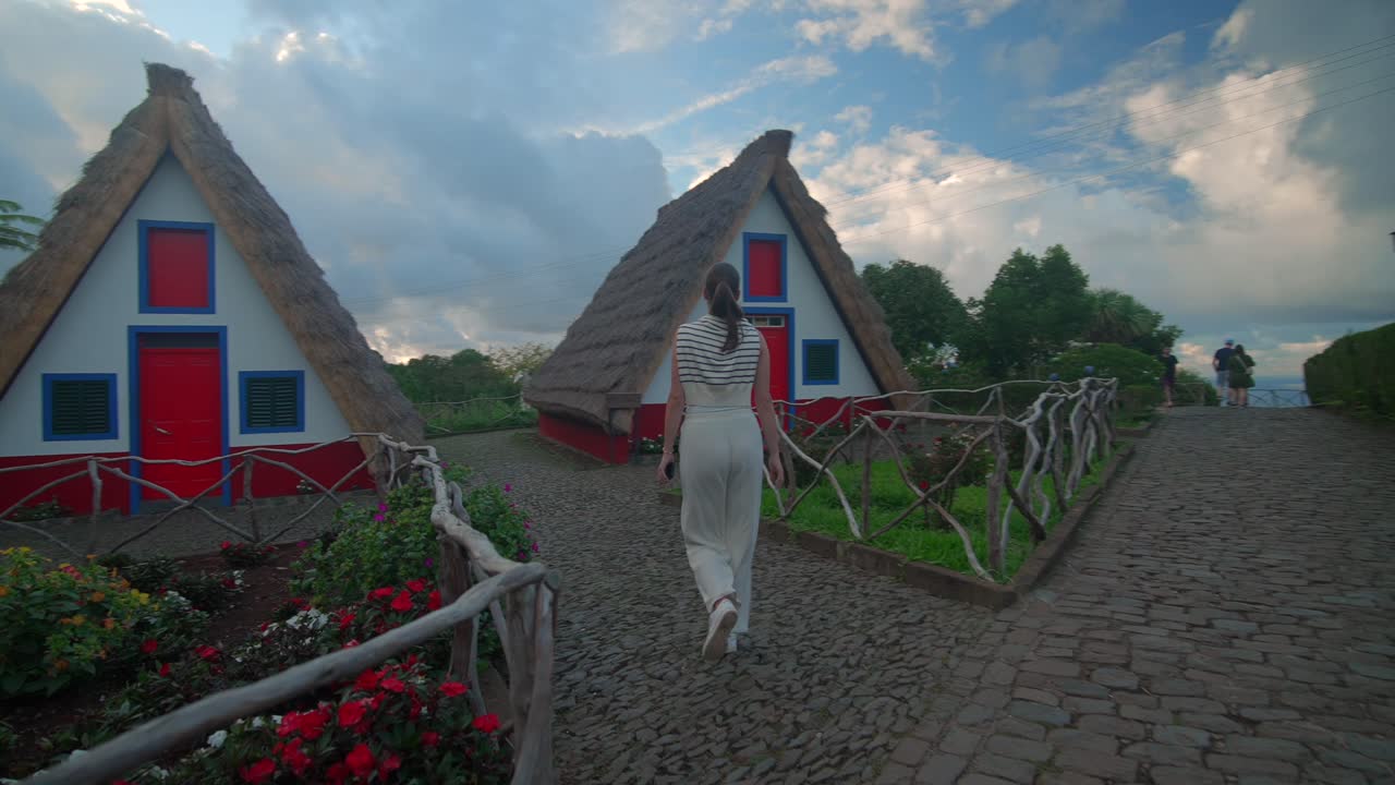 chica modelo caminando por las casas tradicionales en forma de a en santana en portugal madeira